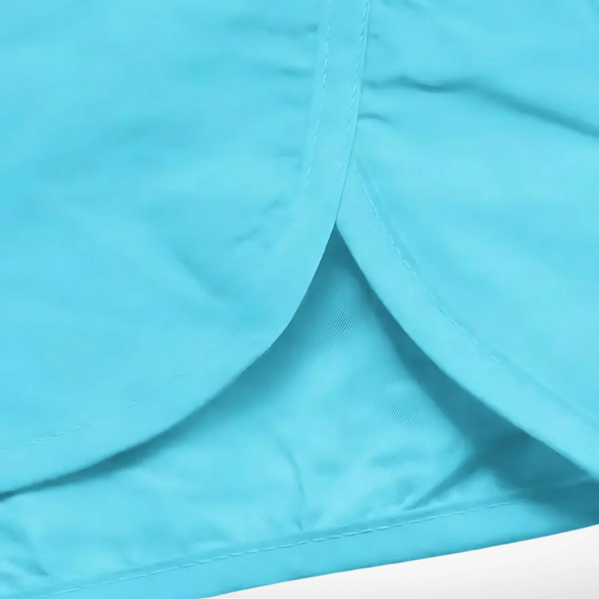 Close-up of aqua blue Classic Short Shorts showing curved side hem and inner mesh lining for breathable, quick-dry performance.