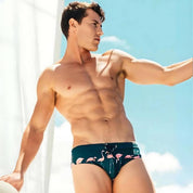 Flamingo Print Swim Briefs – Fun, Quick-Dry Men's Swimwear modeled outdoors, showcasing the front design and snug fit for beach or pool use.