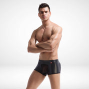 Sheer front faux leather boxer briefs for men featuring a bold mesh panel and sleek black finish. Stretchy fit ideal for stylish, breathable underwear.