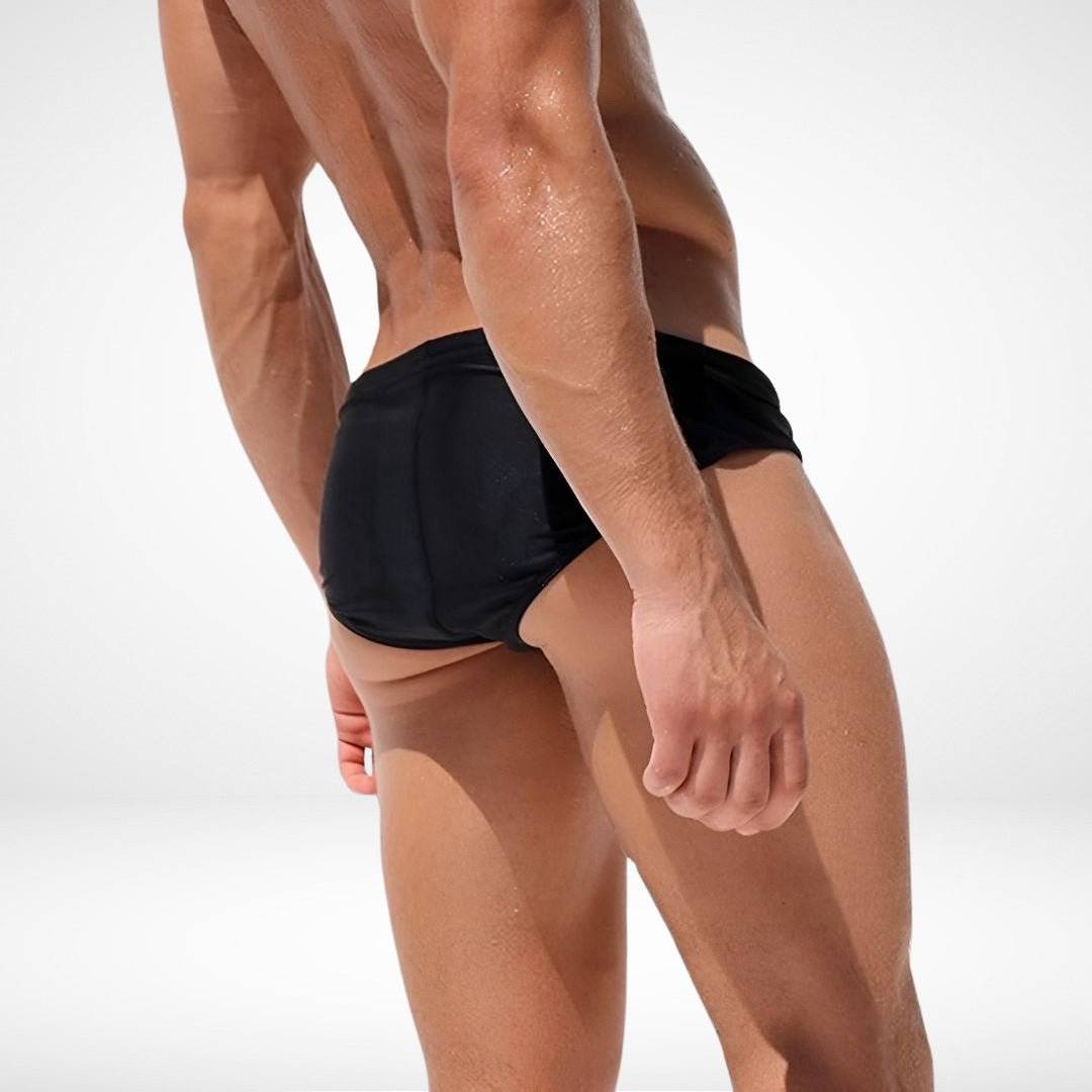 Back view of black men's swim briefs featuring snug fit and moisture-wicking fabric, perfect for swimming or sunbathing.