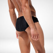 Back view of black men's swim briefs featuring snug fit and moisture-wicking fabric, perfect for swimming or sunbathing.