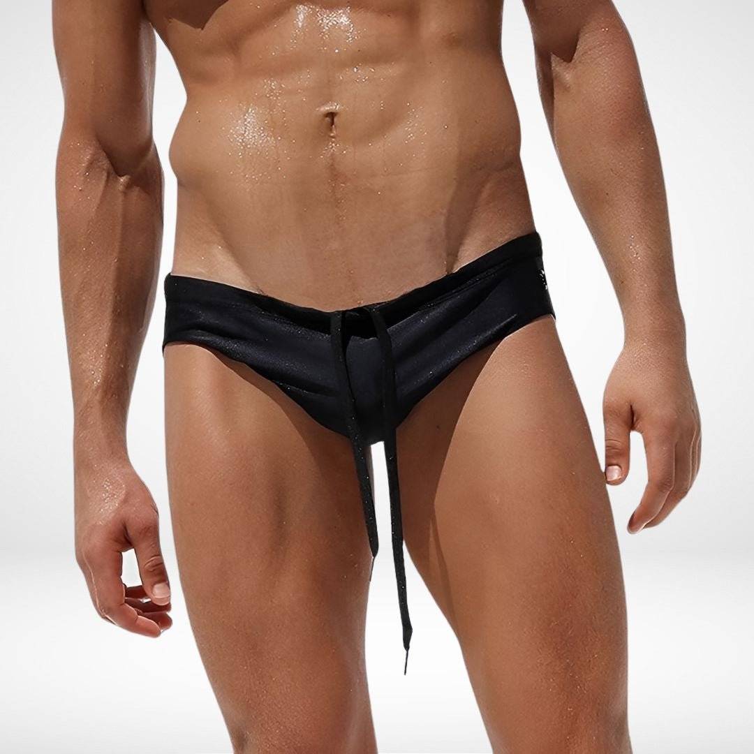 Front view of black men's side eyelet swim briefs with matching drawstring, crafted for sleek, quick-dry swimwear performance.