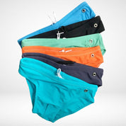Stack of men's side eyelet swim briefs in various colors with drawstrings and metal eyelets, showcasing stylish swimwear options.