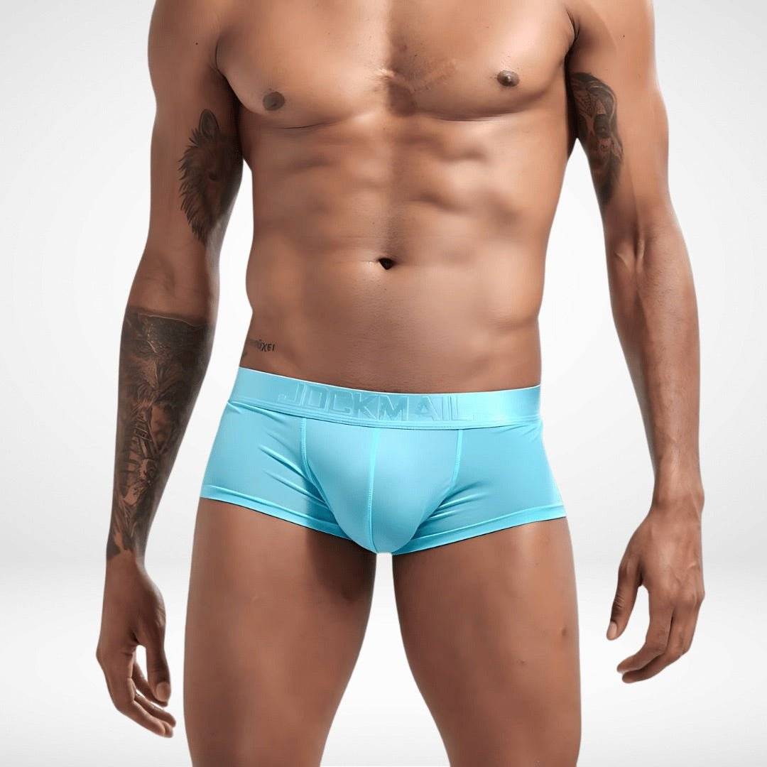 Transparent ice silk boxer briefs in aqua blue worn by male model. Sheer, breathable men's underwear with sleek fit and bold color.