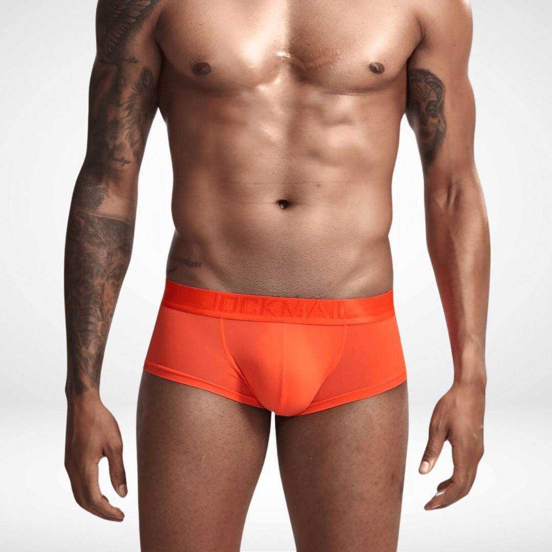 Bright orange transparent ice silk boxer briefs on male model. Sheer, form-fitting men's underwear with bold, vibrant appeal.