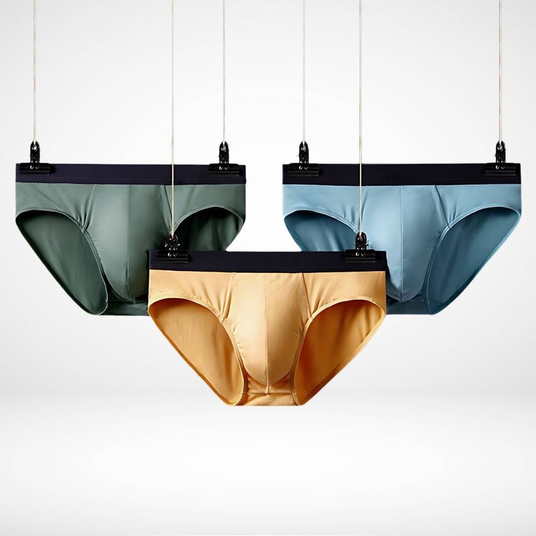 Three hanging Soft Modal Comfort Fit Men's Briefs in green, yellow, and blue, showcasing breathable fabric and stretch waistband.