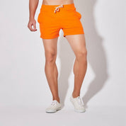 Front view of UrbanFit Basics Everyday Shorts in orange, featuring a modern fit, deep pockets, and soft stretch fabric.