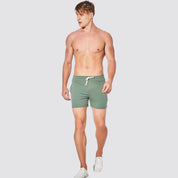 UrbanFit Basics Everyday Shorts in olive green, modeled shirtless, offering a relaxed fit and breathable cotton blend for casual wear.