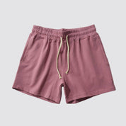 Flat lay of UrbanFit Basics Everyday Shorts in dusty rose, with elastic waistband and dual pockets for casual versatility.