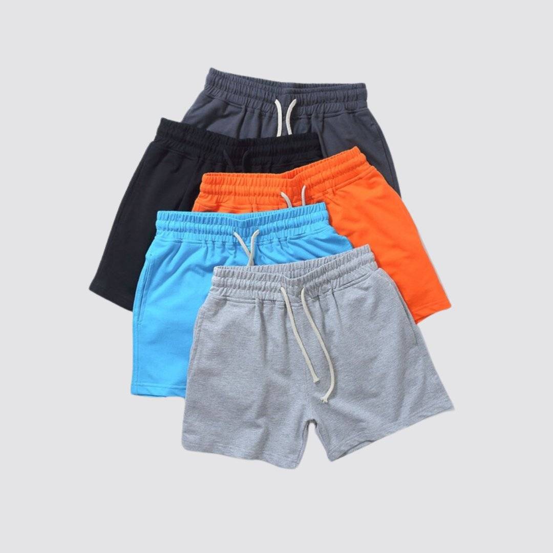 UrbanFit Basics Everyday Shorts multipack in five colors—black, charcoal, orange, blue, and grey—made from stretch cotton for versatile casual wear.