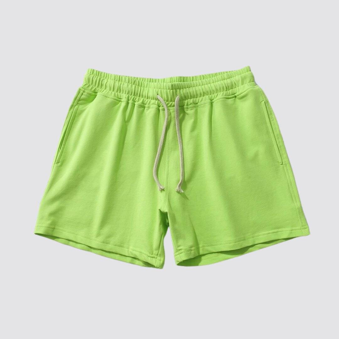 Flat lay of UrbanFit Basics Everyday Shorts in neon green, with elastic waistband and side pockets, perfect for casual wear.